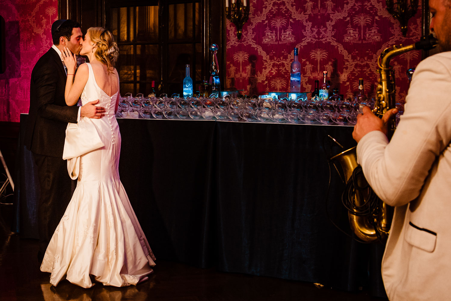 Bride and groom kiss under the sounds of saxophon