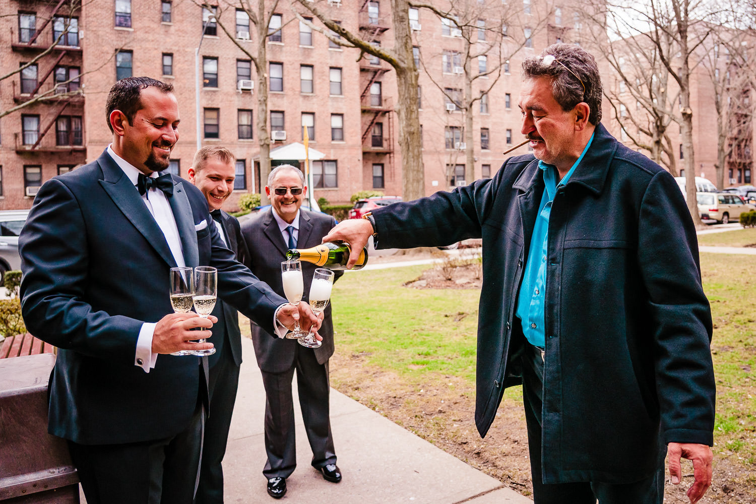 Bride's father pour champagne glasses on a street in Brooklyn 