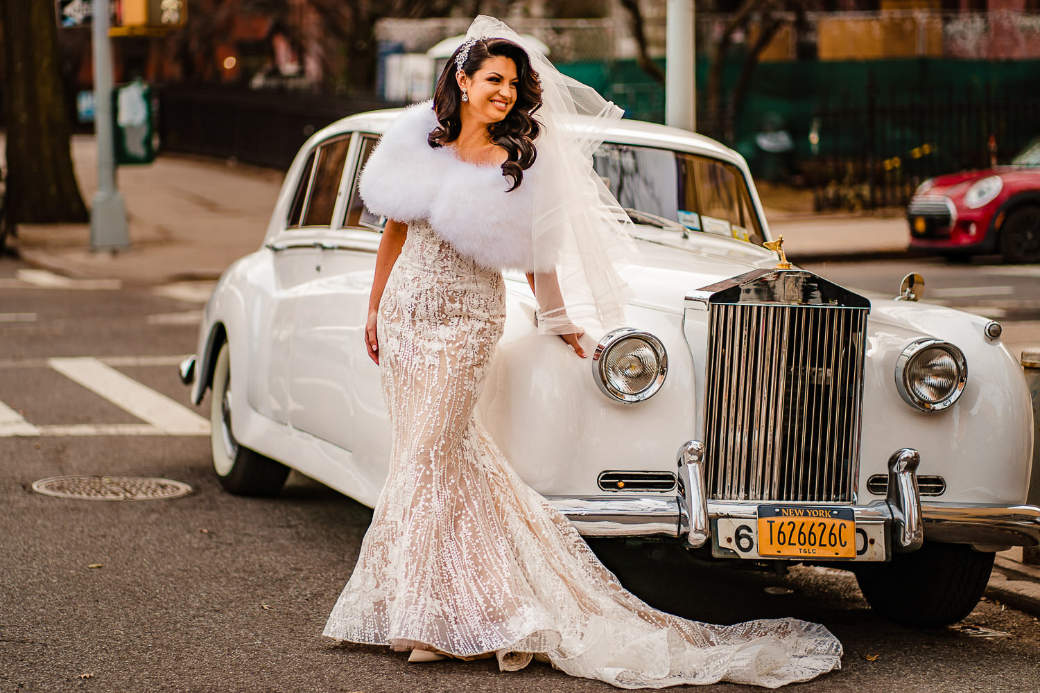 Bride poses in front of limo before ceremony at Park Slope Jewish center