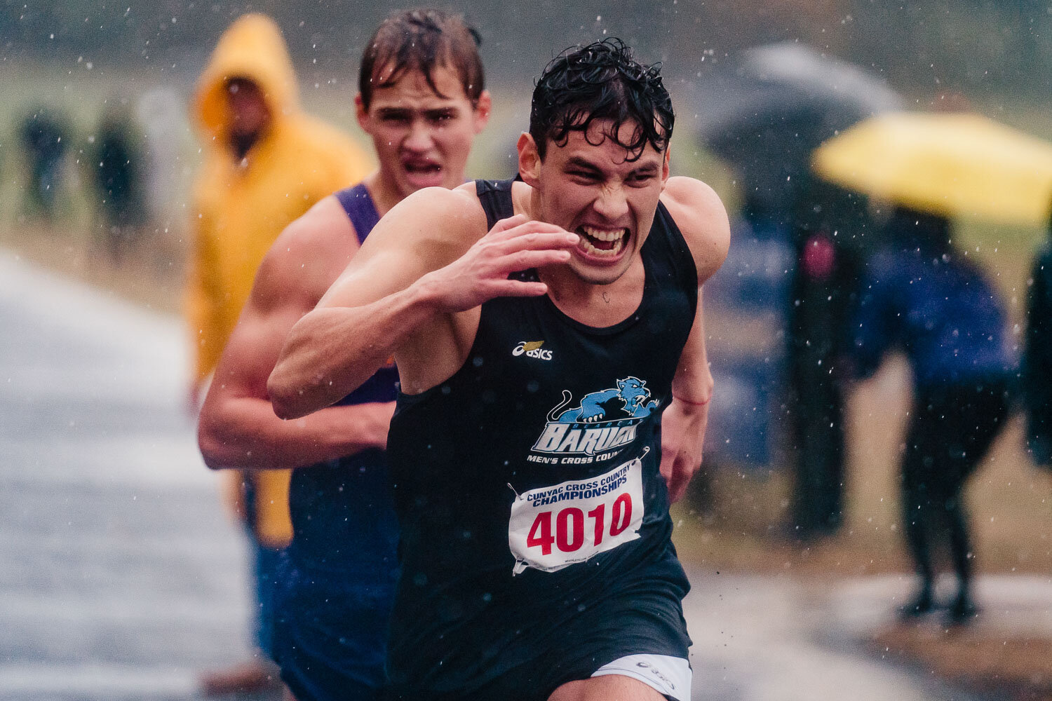 Baruch runner crosses finish line during CUNYAC Championship race at van cortlandt park