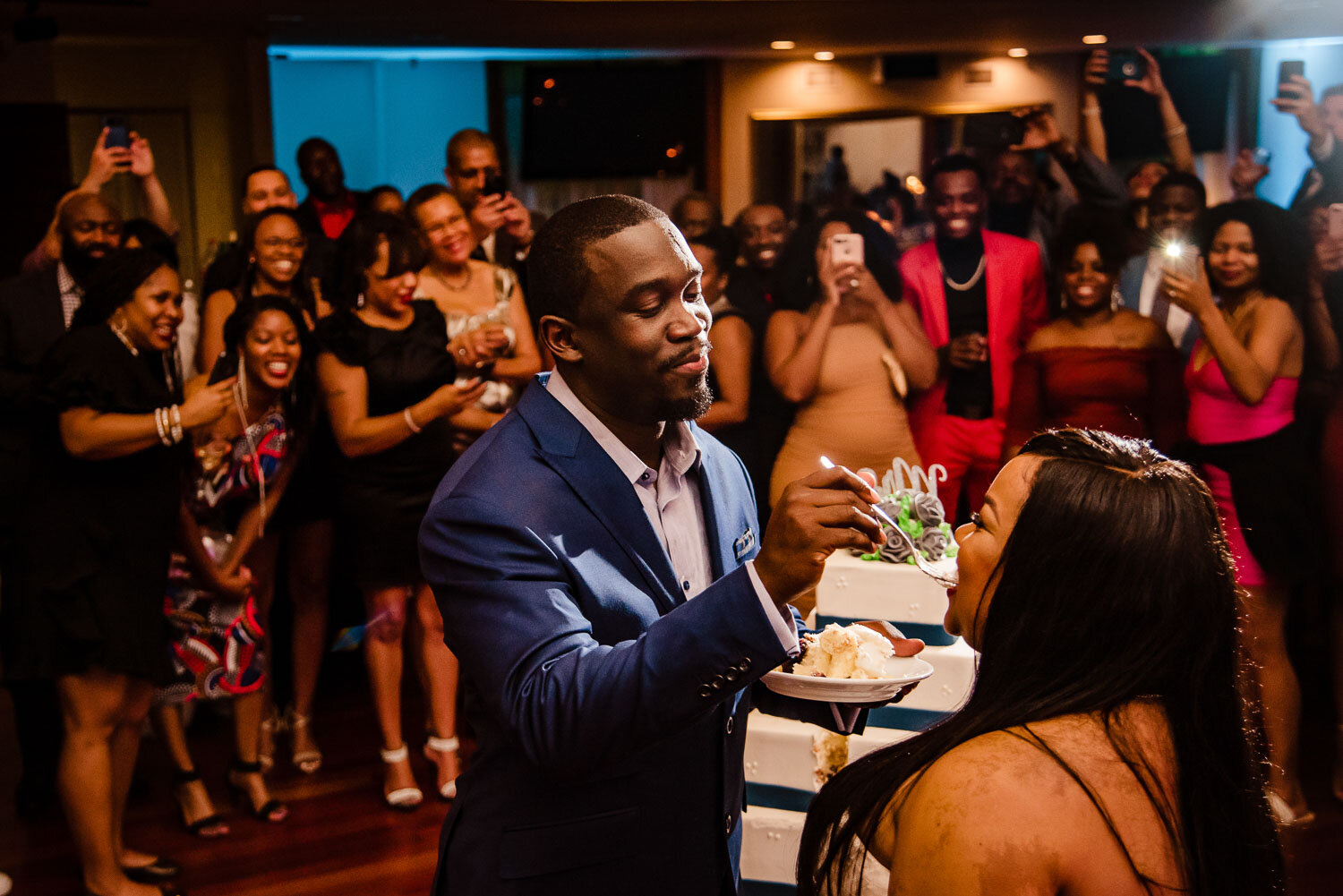 Groom feeds bride a cake at The Metropolitan Caterers in Glen Cove 