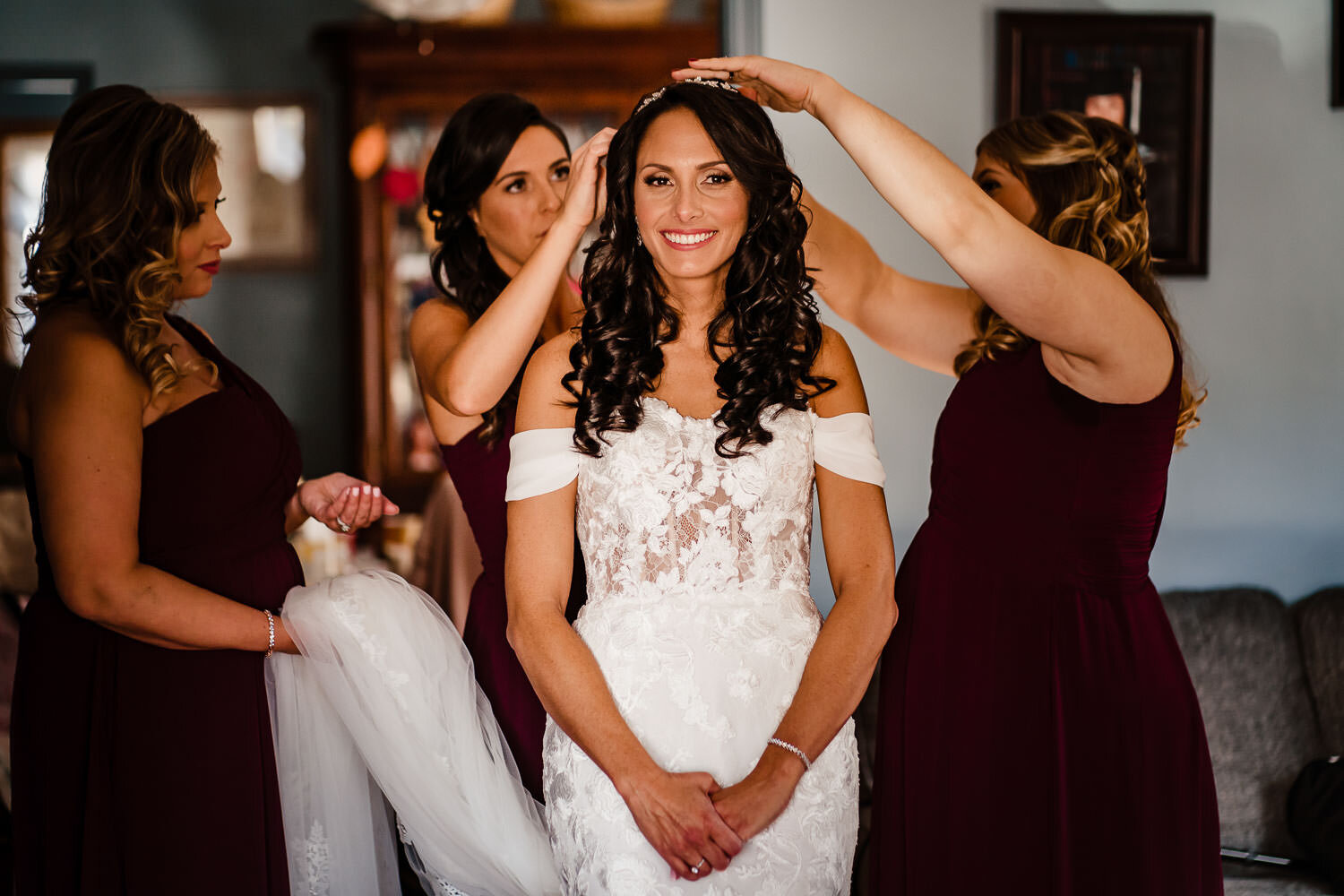 Bridesmaids help the bride with her veil during preparations