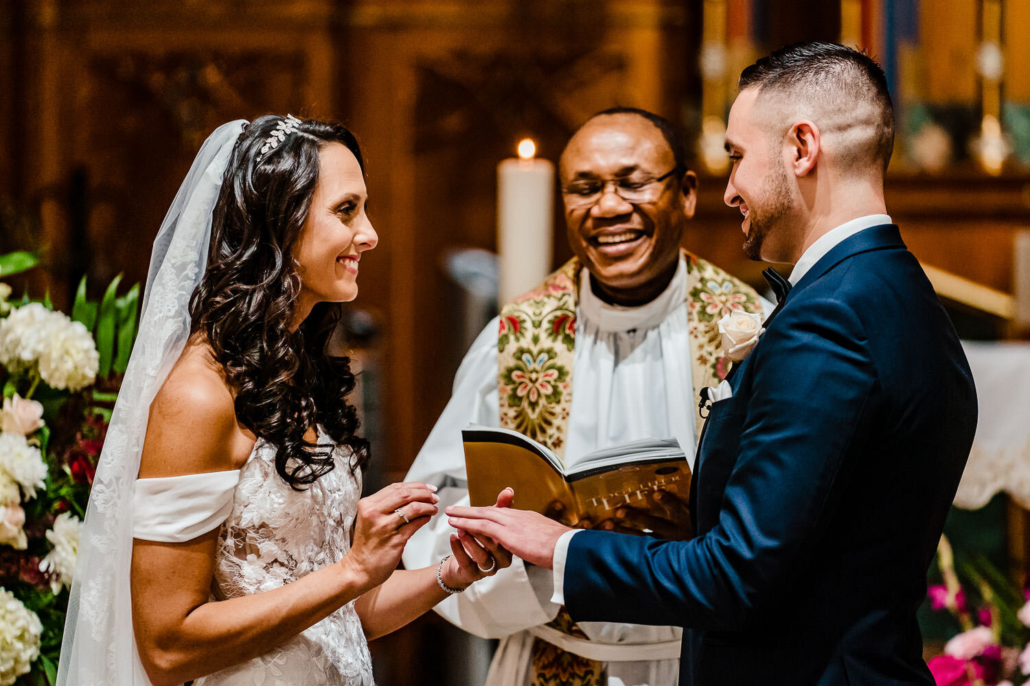 Bride and groom exchange rings during ceremony at St. Margaret C