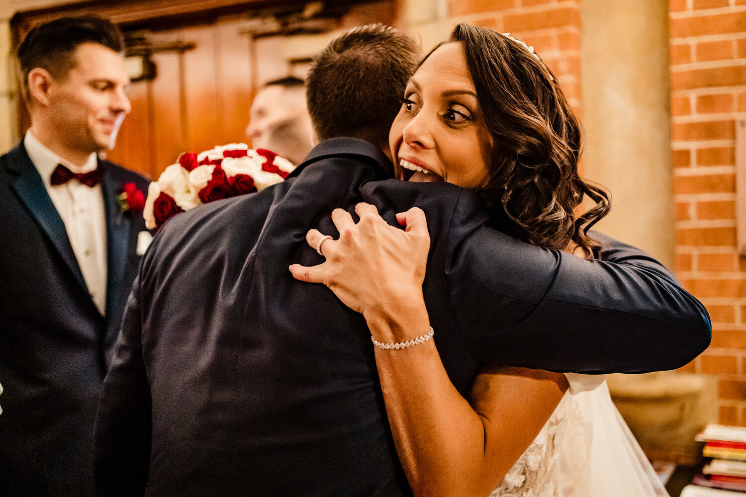 Bride hugs a guest after the ceremony at St. Margaret Catholic S