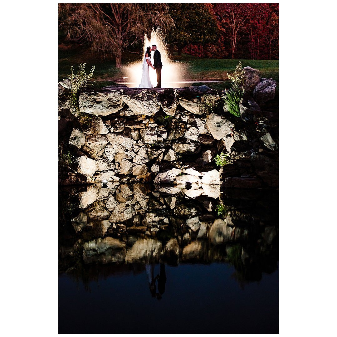 Newlyweds kiss near waterfall at Royalton on the Greens in Melvi