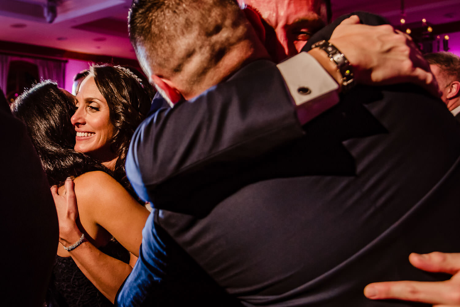 Bride and groom hug guests on the dance floor at Royalton on the