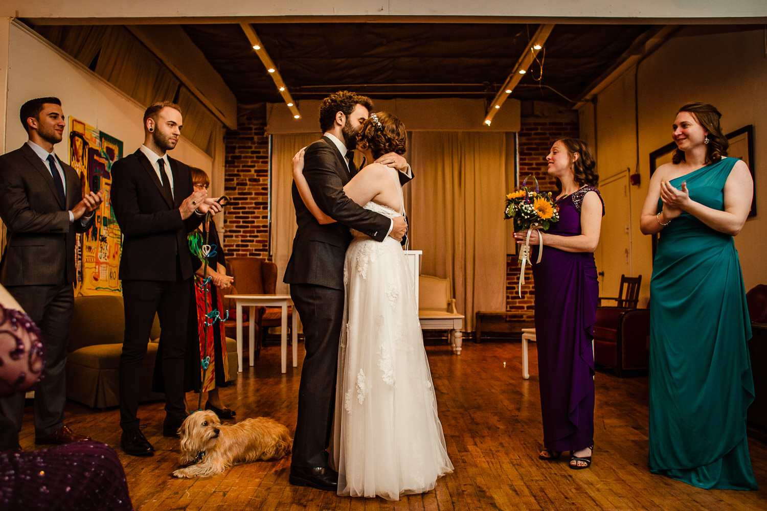 Bride and groom kiss during ceremony at Aurora Gallery in Long Island City