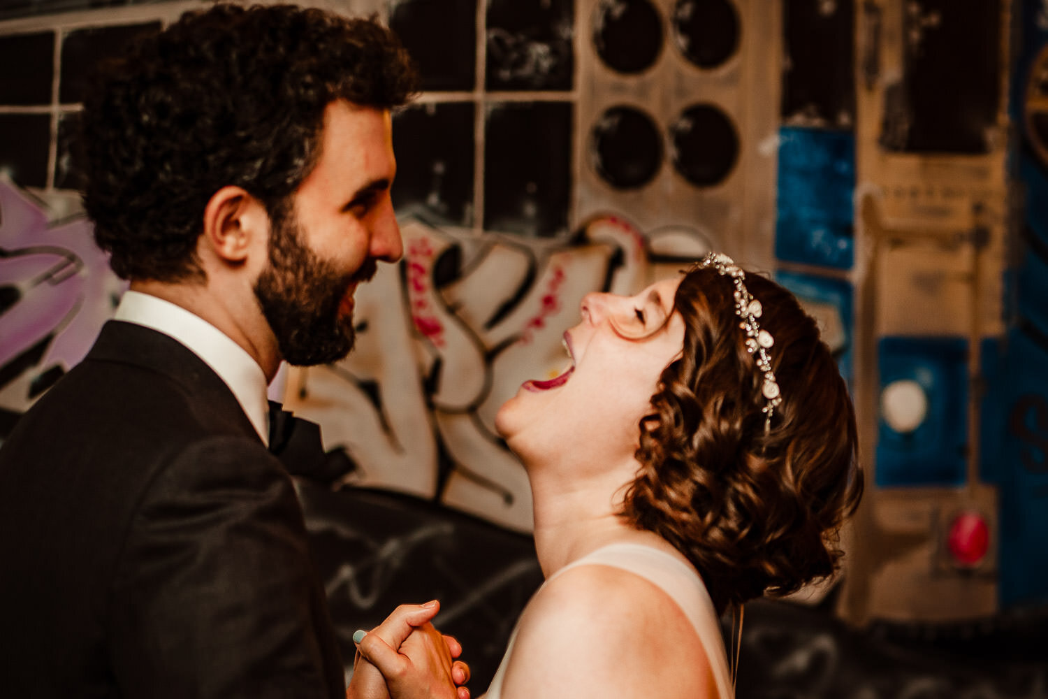 Bride and groom laugh during reception at Aurora Gallery in Long Island City