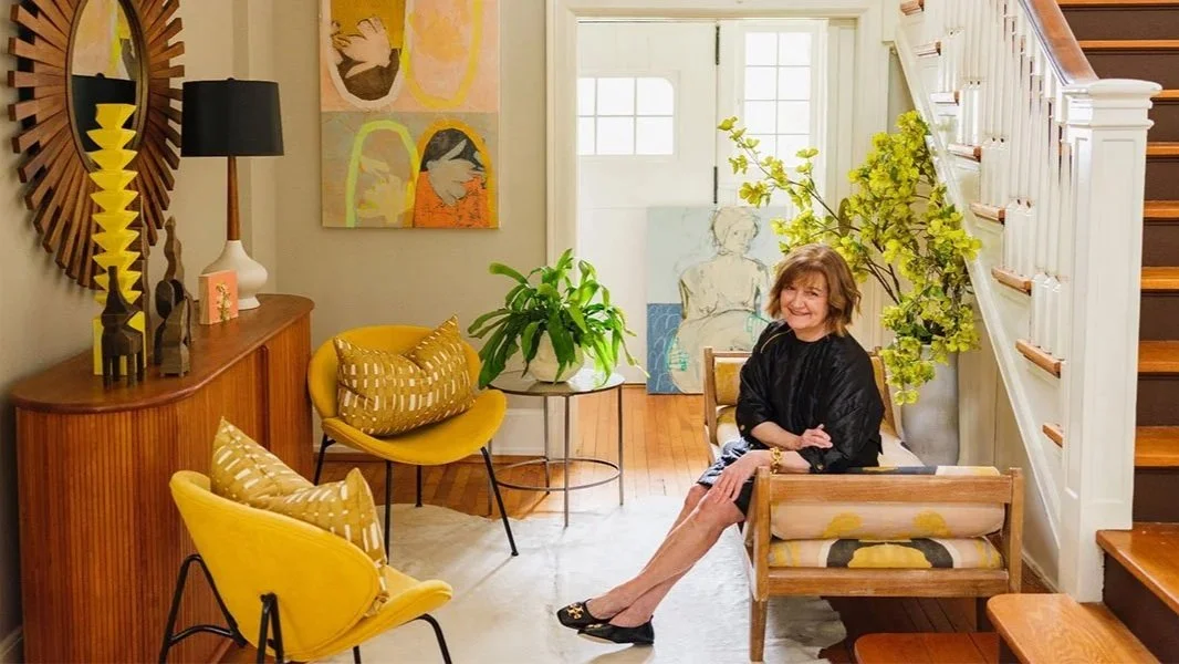 Kathy Harris, founder and designer of the kottkomm clothing line, sits in her sun-lit foyer, which is decorated in bright colors and mid-Century modern decor