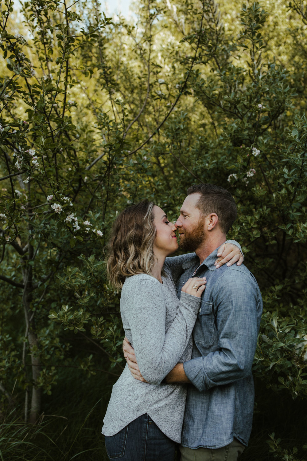 An engaged couple embrace at discovery park in seattle