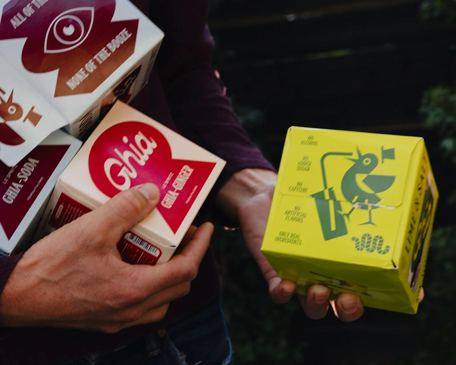 Person holding various food cartons, including a pink and white carton of Gabi brand, and a yellow carton with a cartoon chicken on it.