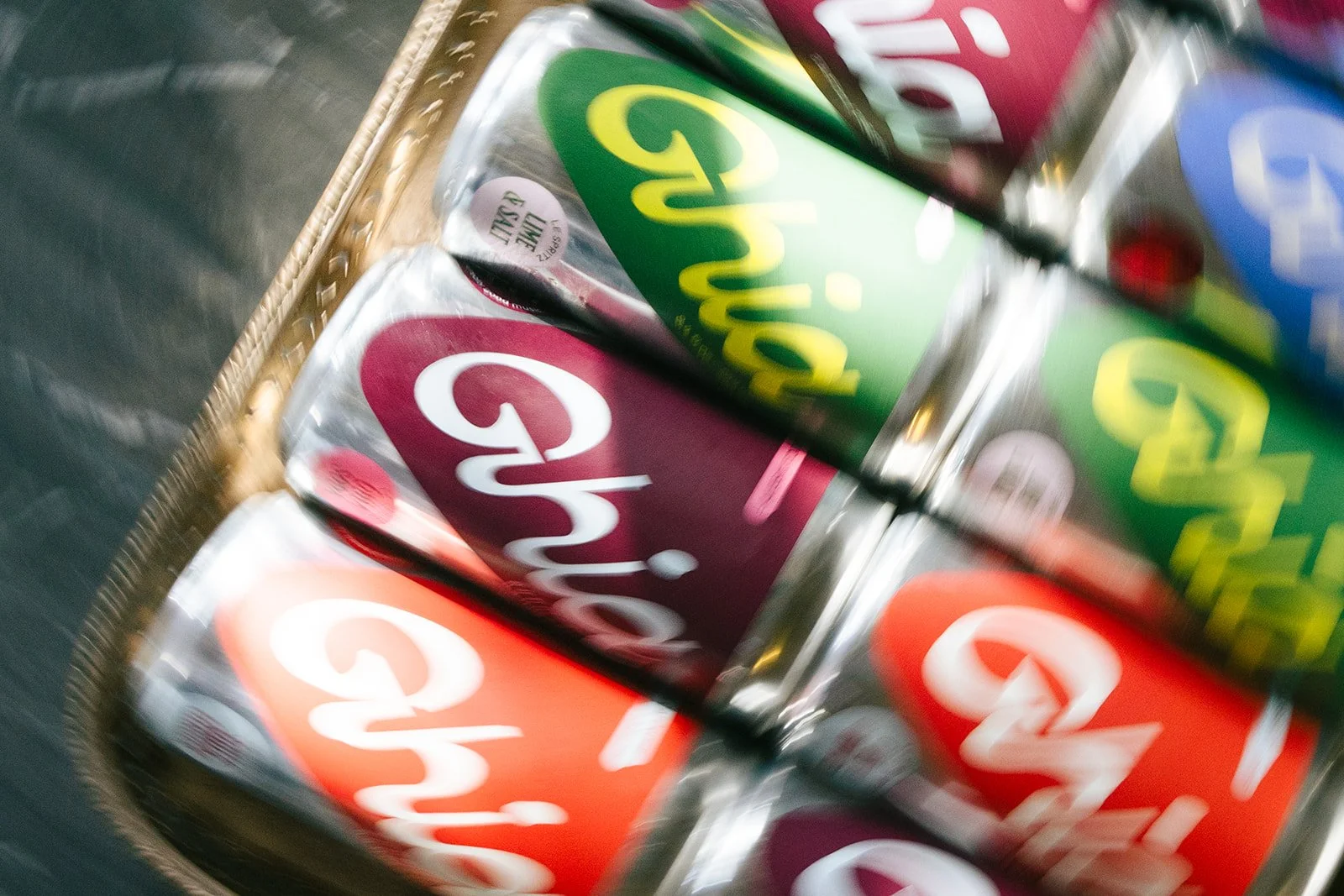 A basket containing multiple cans of Chi-Hi soda in various flavors, with red, green, and purple labels.
