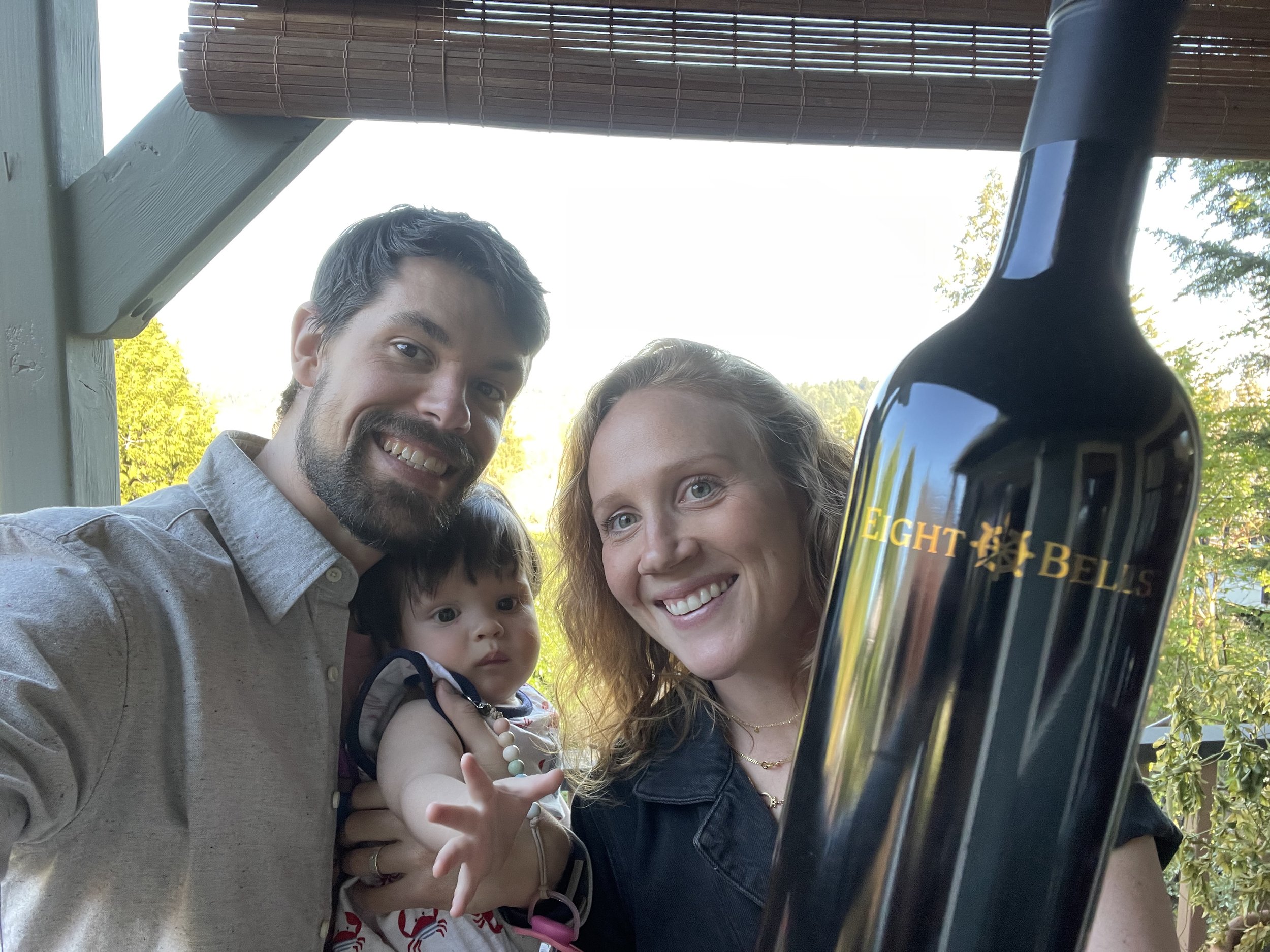 A family with a large bottle of Eight Bells wine