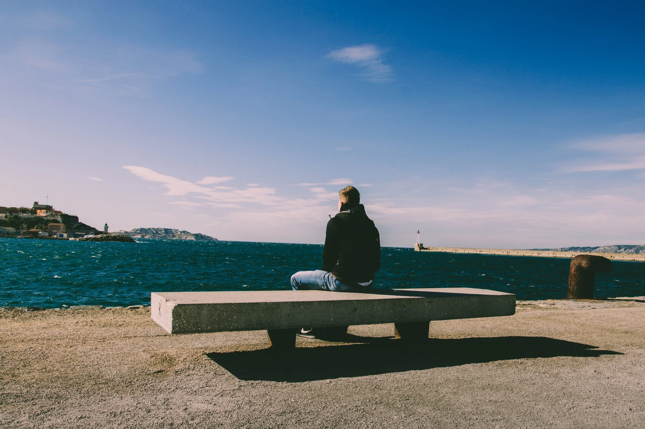 person-wearing-blue-jeans-sitting-on-bench-1074535.jpg