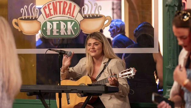 Friends Experience - Lady sat in Central Perk with Phoebe's Guitar