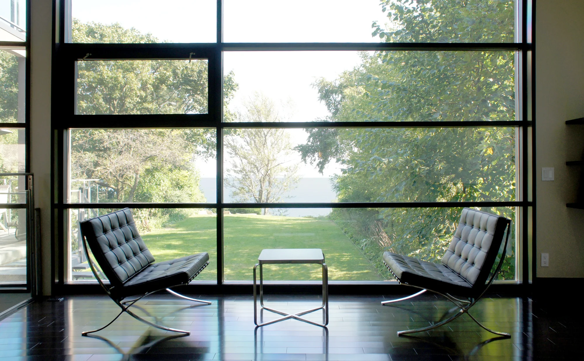 Floor-to-ceiling windows covering the rear facade allow light to flood into the house and give the owners unobstructed views of the garden and lake beyond.