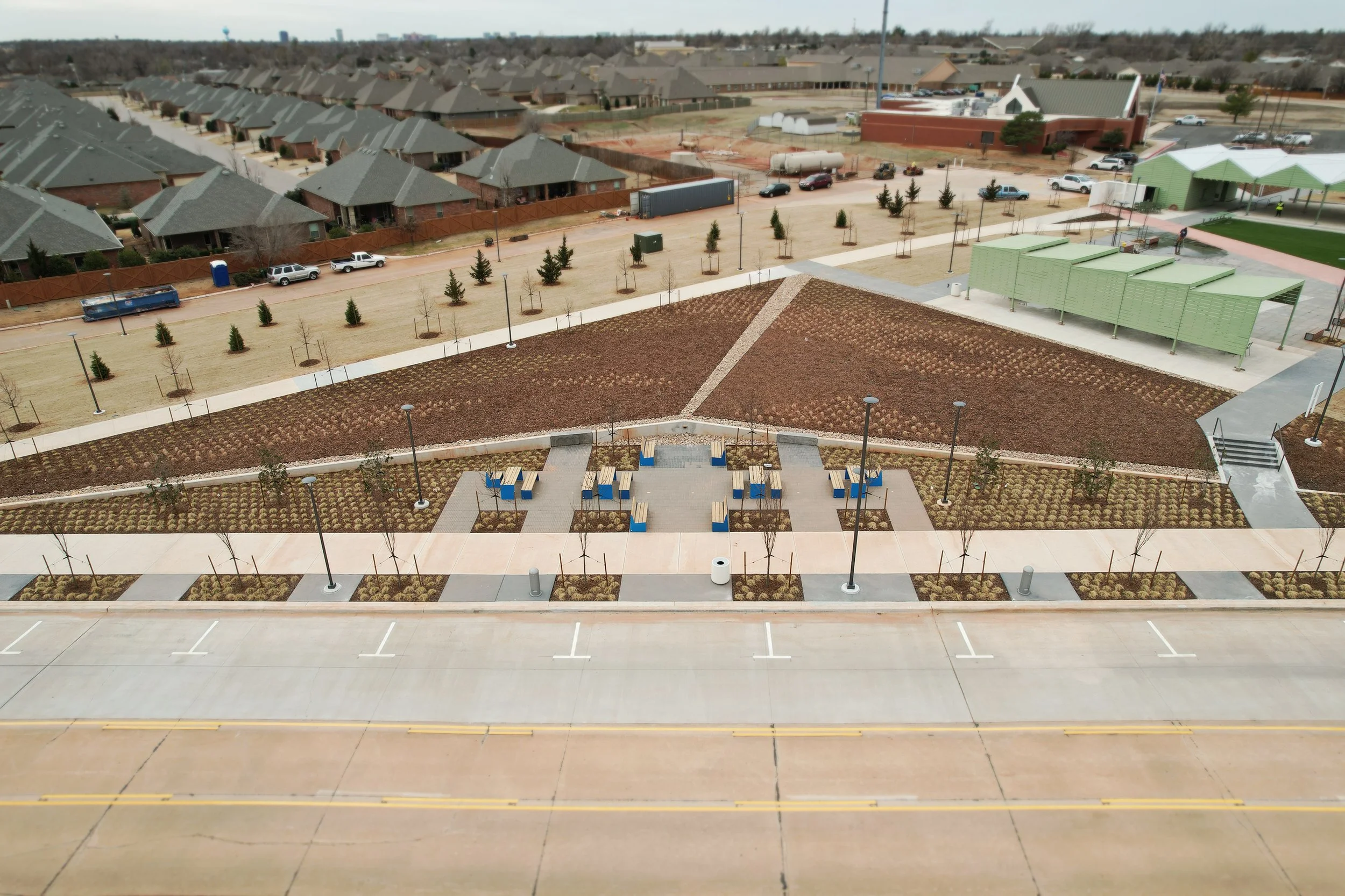  The angled slope defines and surrounds the Lower Plaza. Prairie grasses are arranged in sweeps with pockets of perennial flowers to naturalize over time. Evergreen trees are placed to grow into screening for the adjacent neighborhood. 