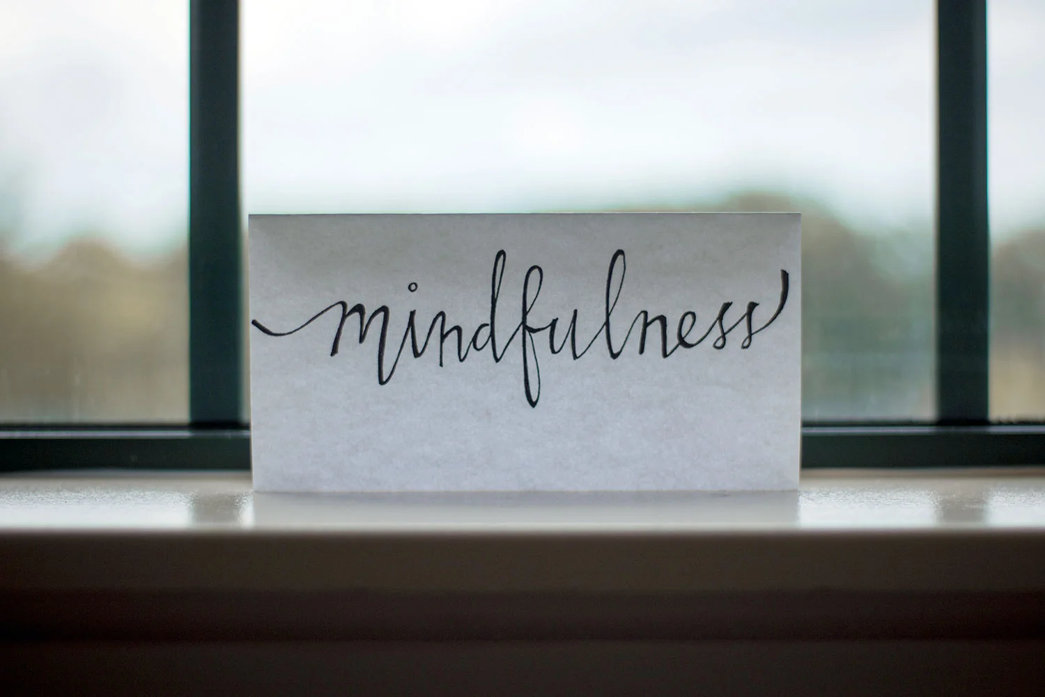 photo of paper placed in window with mindfulness written on it to represent and introduction to mindfulness course in gloucestershire.jpg