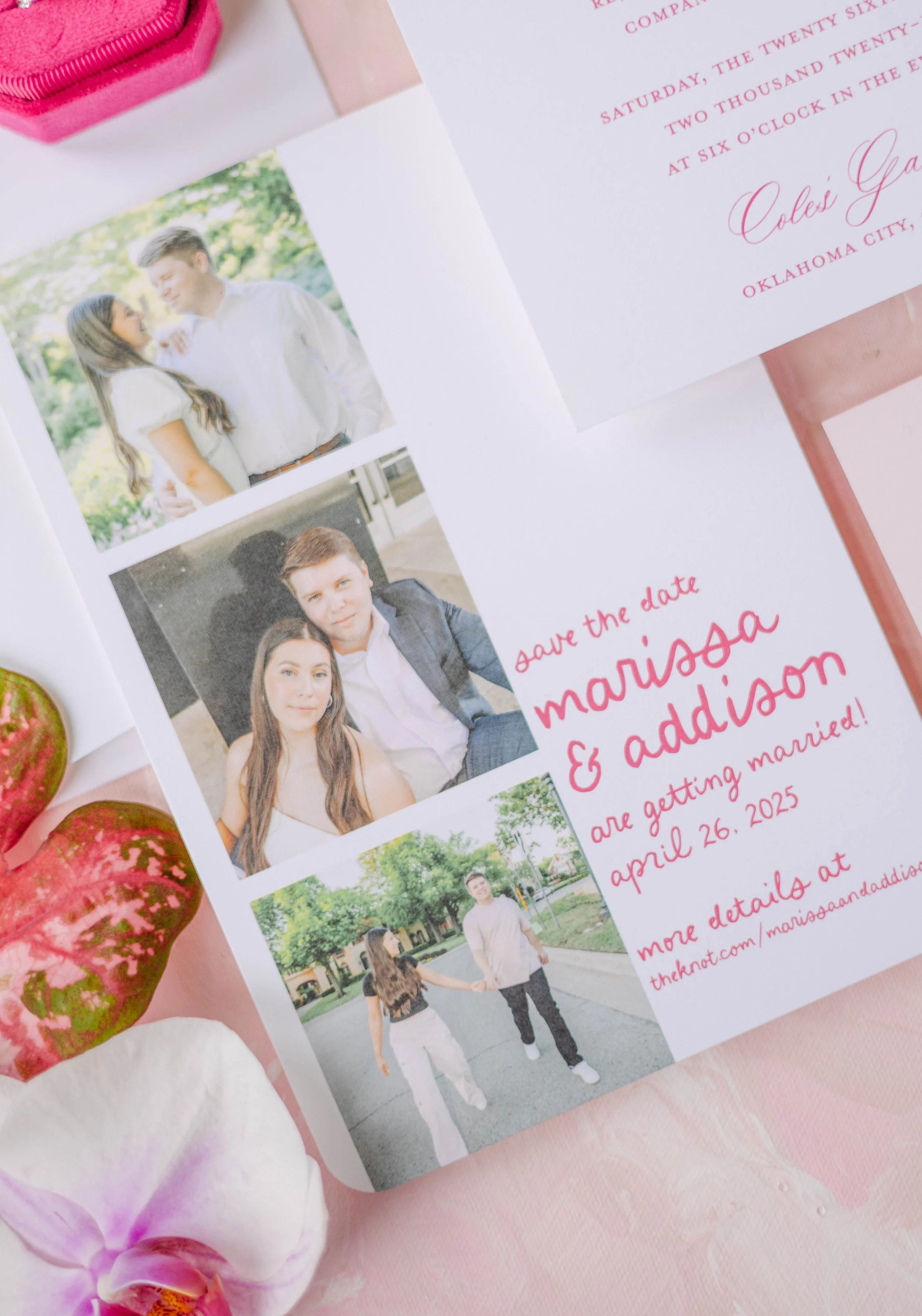 Invitation card for a wedding with photos of the couple and text details including date and location, along with pink orchids and strawberries placed on a pink surface.