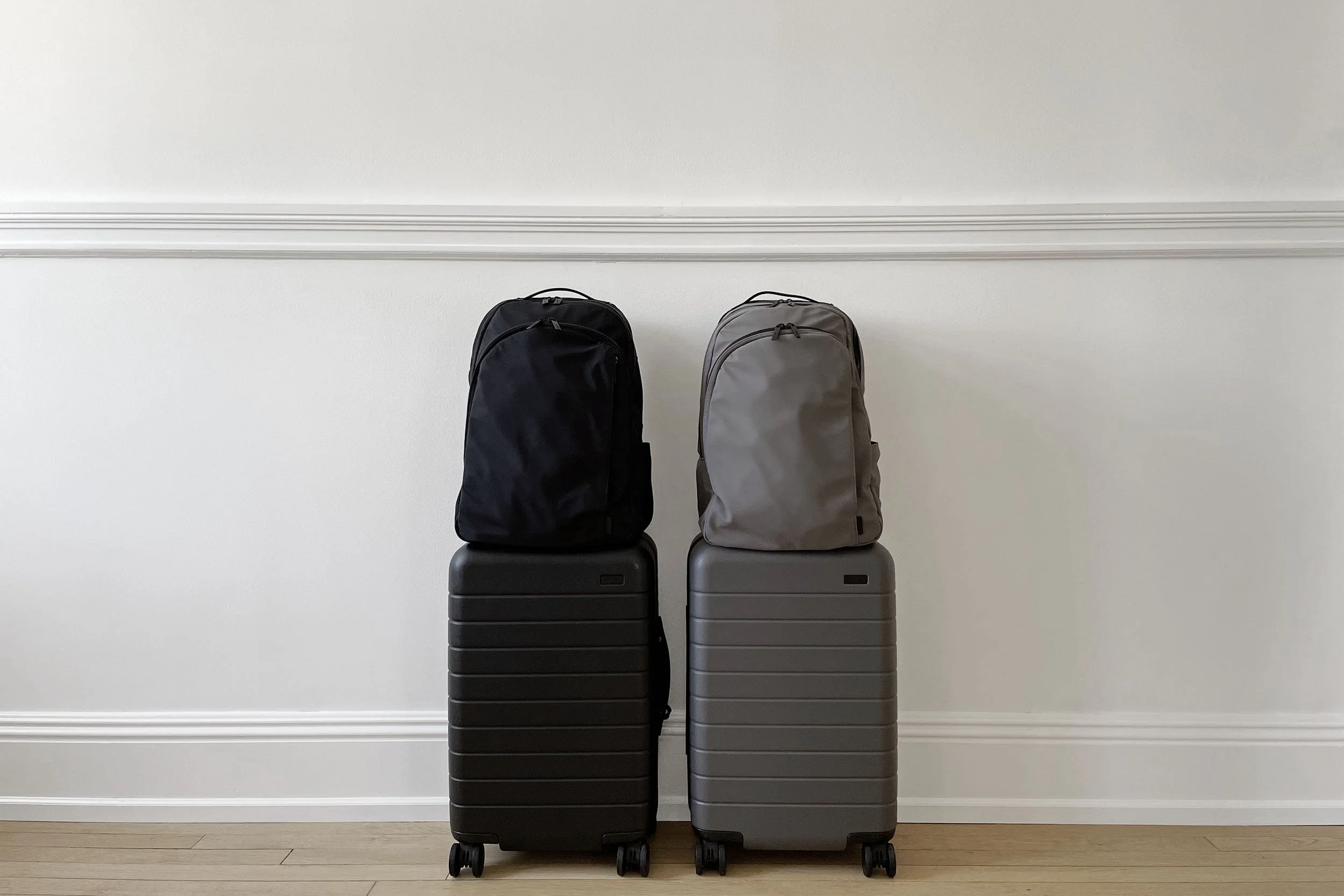 Two minimalist carry-on suitcases and matching backpacks