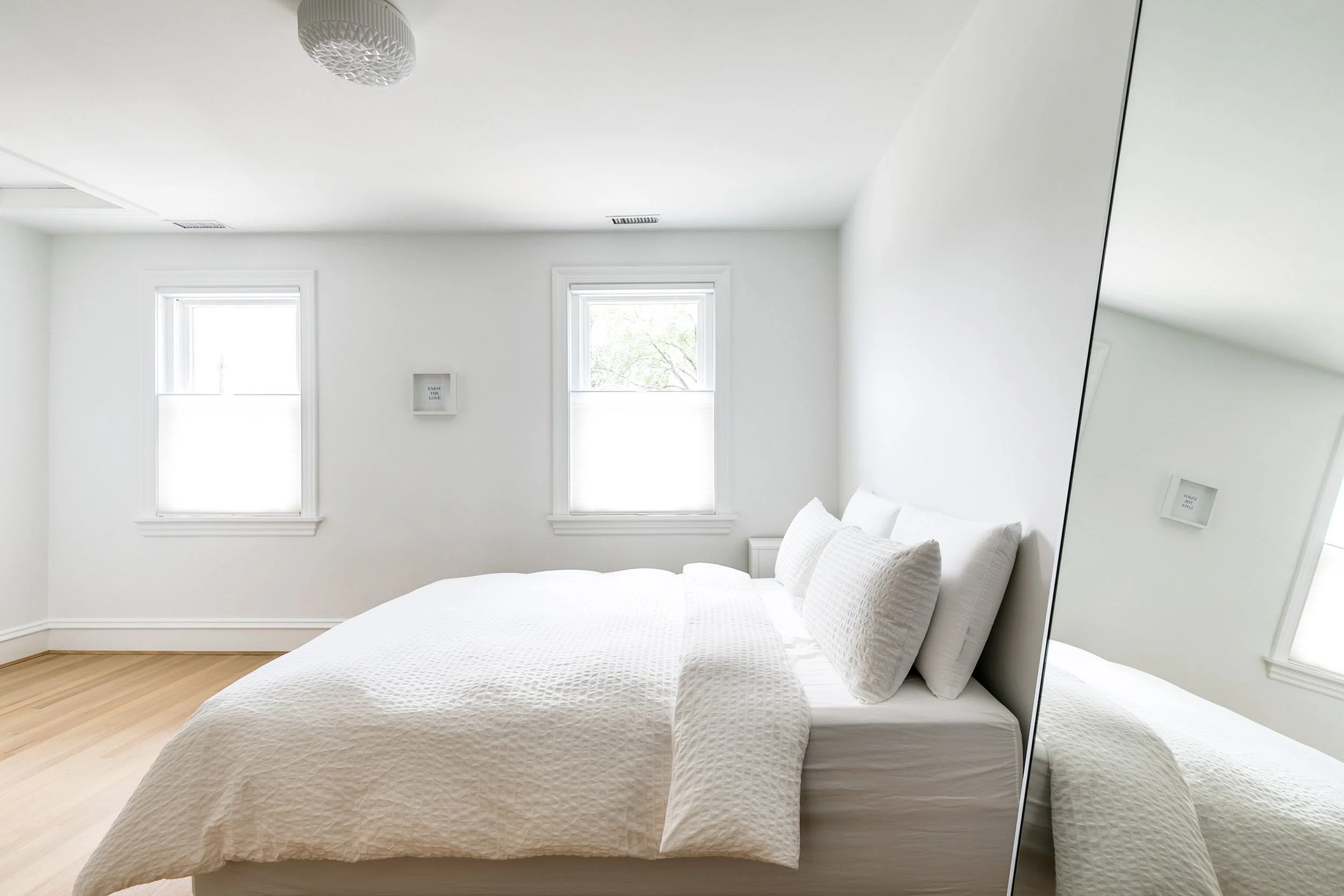 Minimalist white bedroom with crisp bedding and natural light