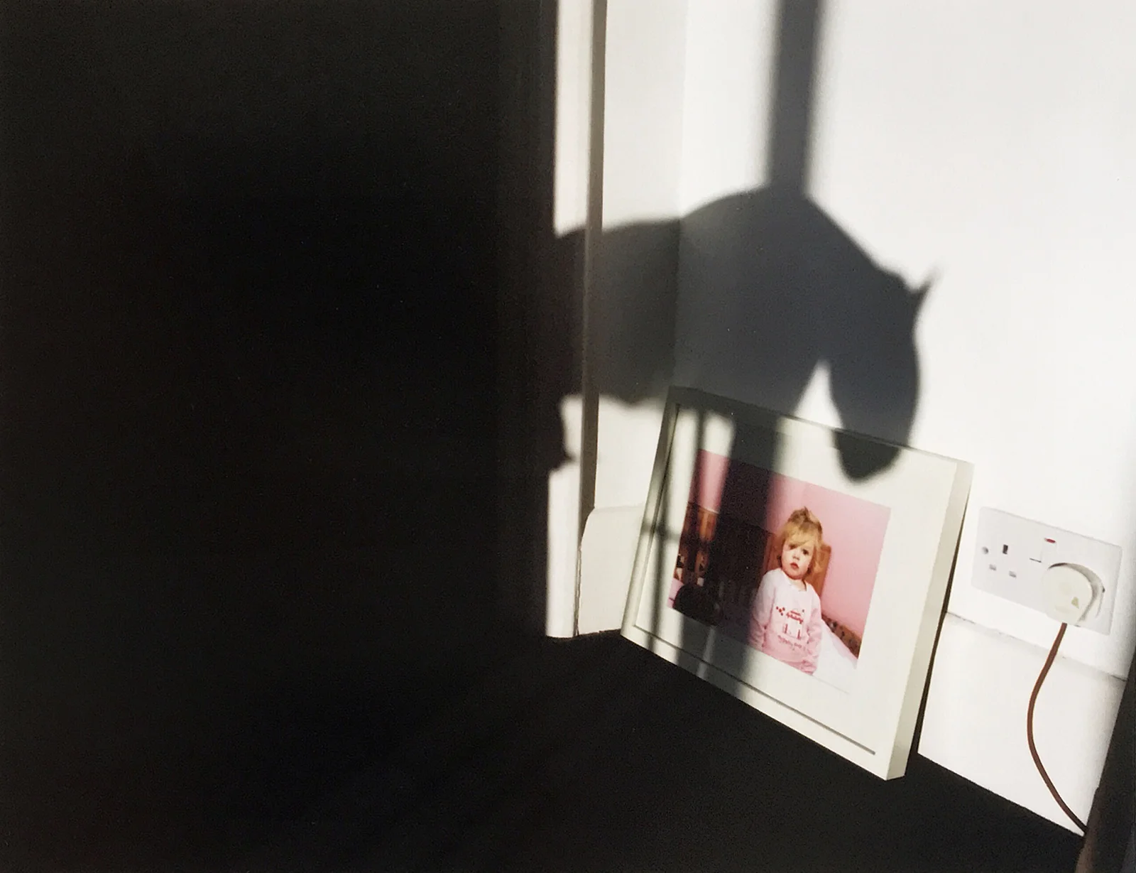A shirt over an ironing board becomes a looming shadow, Brighton UK, 2012 © Tanya Clarke