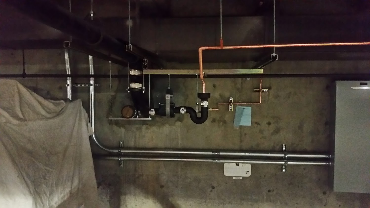 Cast iron Hub Drain in parking garage with indirect copper drain. Non combustible piping