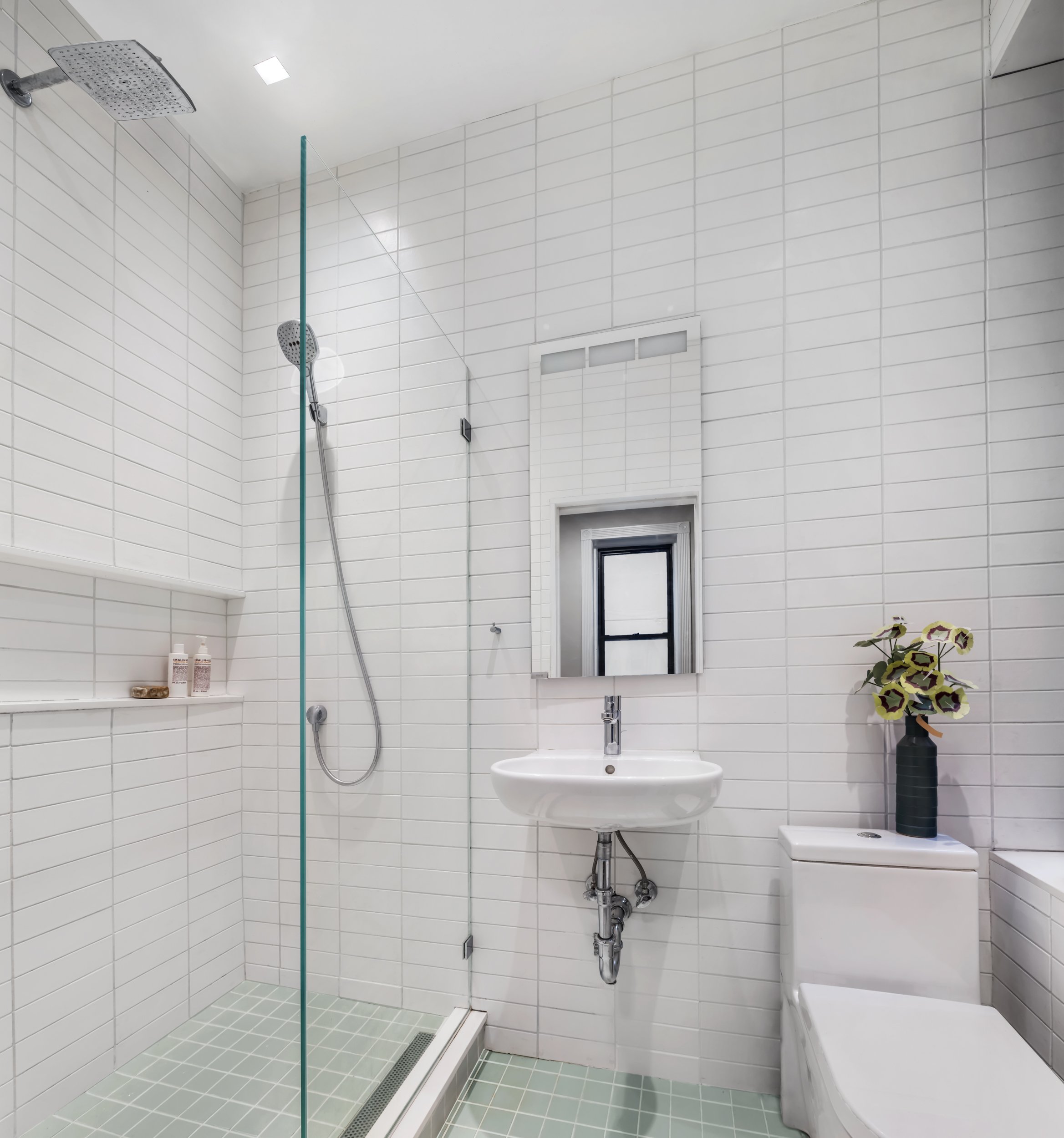 The bathroom was completely redone with new fixtures, finishes, and a large, walk-in shower to replace the existing bathtub.