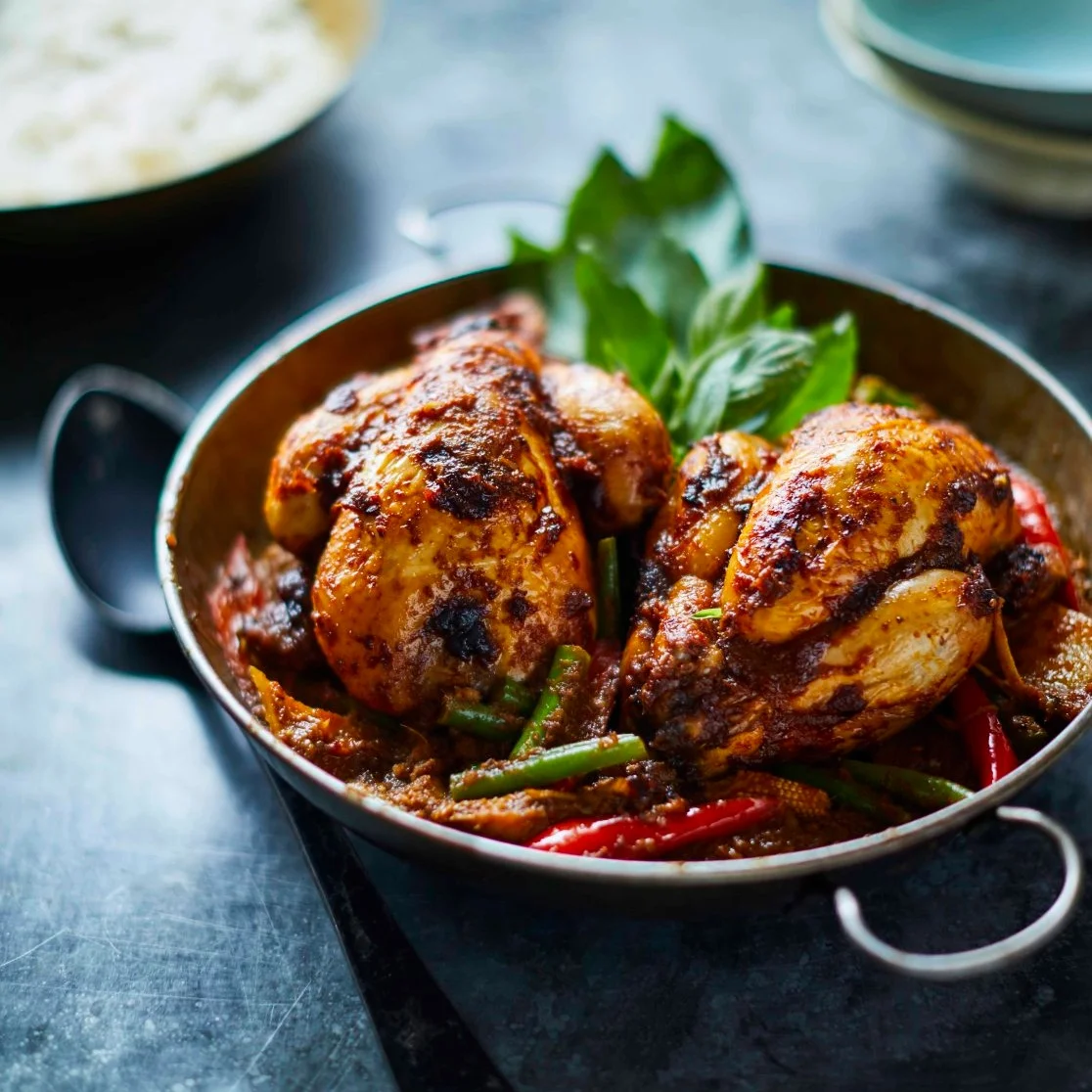 Whole roasted baby chicken coated in red curry paste in a dark wok with sweet basil, minced prawns, baby corn and Asian vegetables, a Farang London recipe by Sebby Holmes