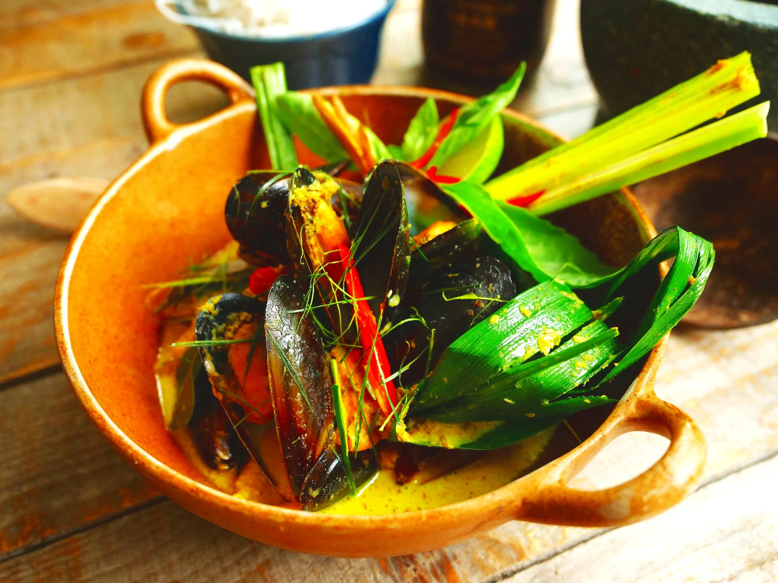 Green curry of mussels with wild ginger, baby corn, green beans and Thai basil in a clay pot with vermicelli noodles, recipe by Sebby Holmes