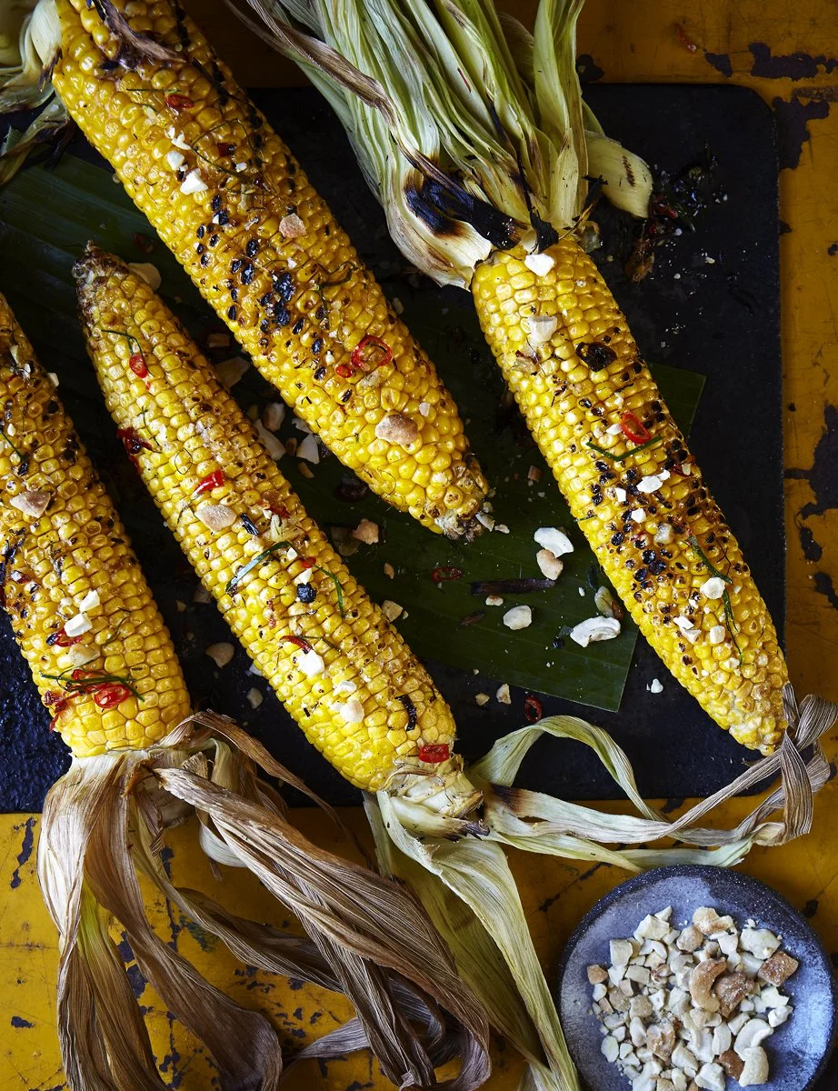 Charred corn on the cob with makrut lime, chilli and crushed cashew nuts on a banana leaf
