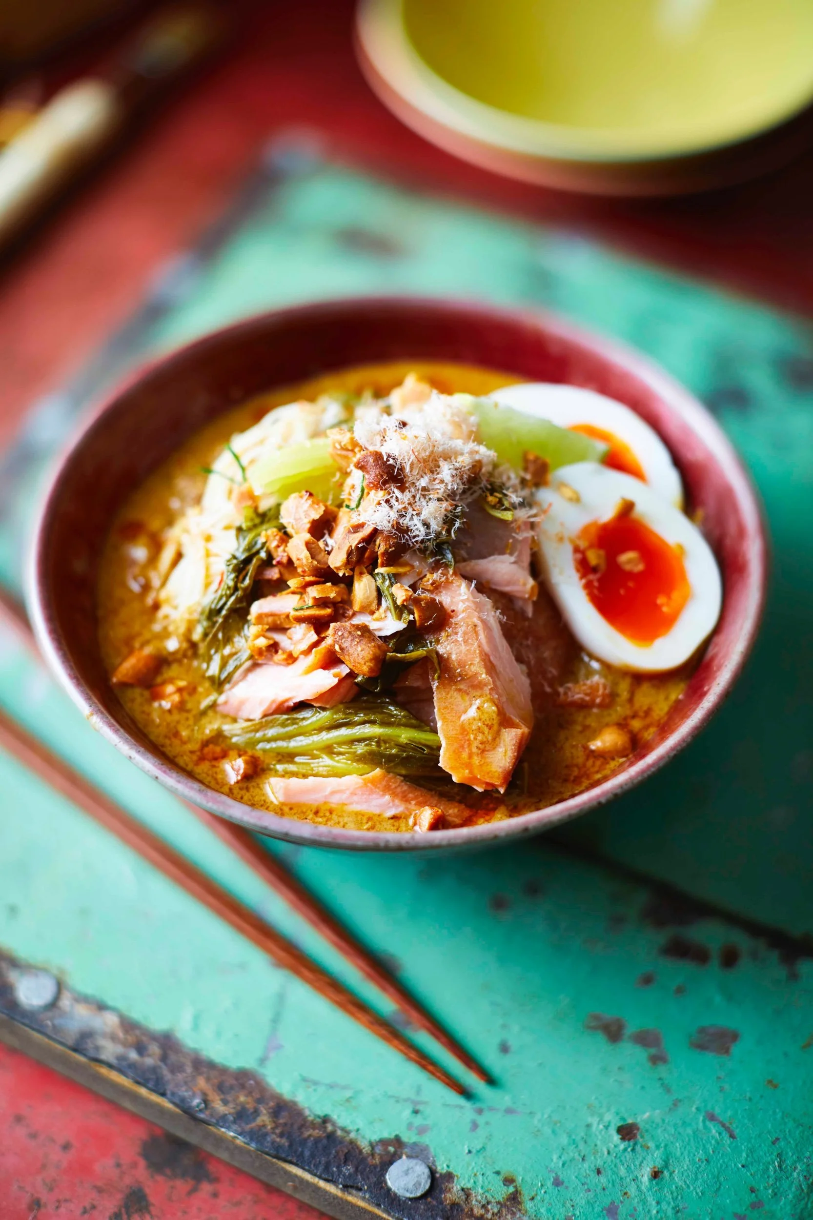 Smoked salmon laksa with rice noodles, soft-boiled eggs, peanuts and pickled mustard greens, recipe by Sebby Holmes