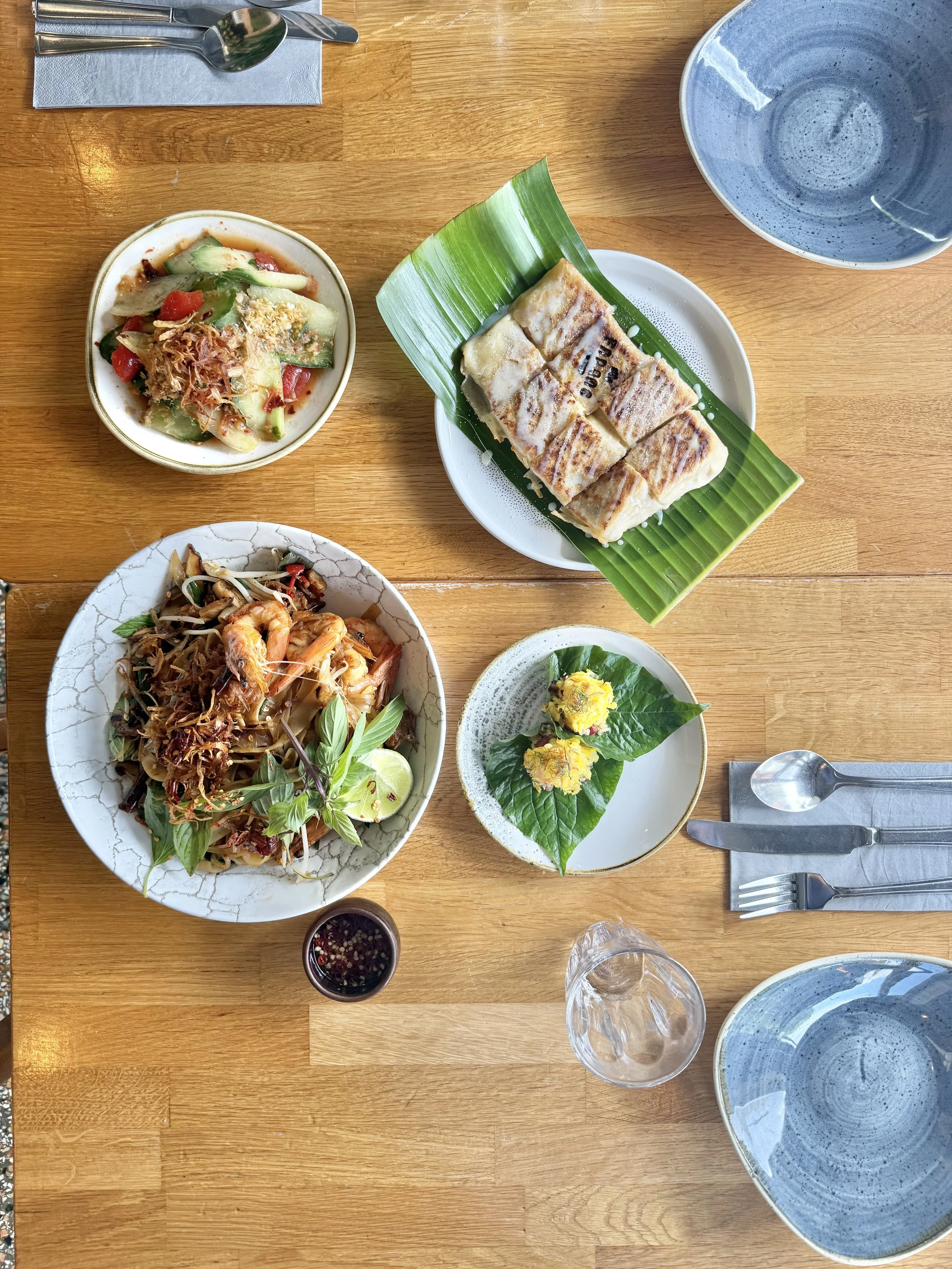 Farang dishes including miang and banana roti on the table, by Sebby Holmes.