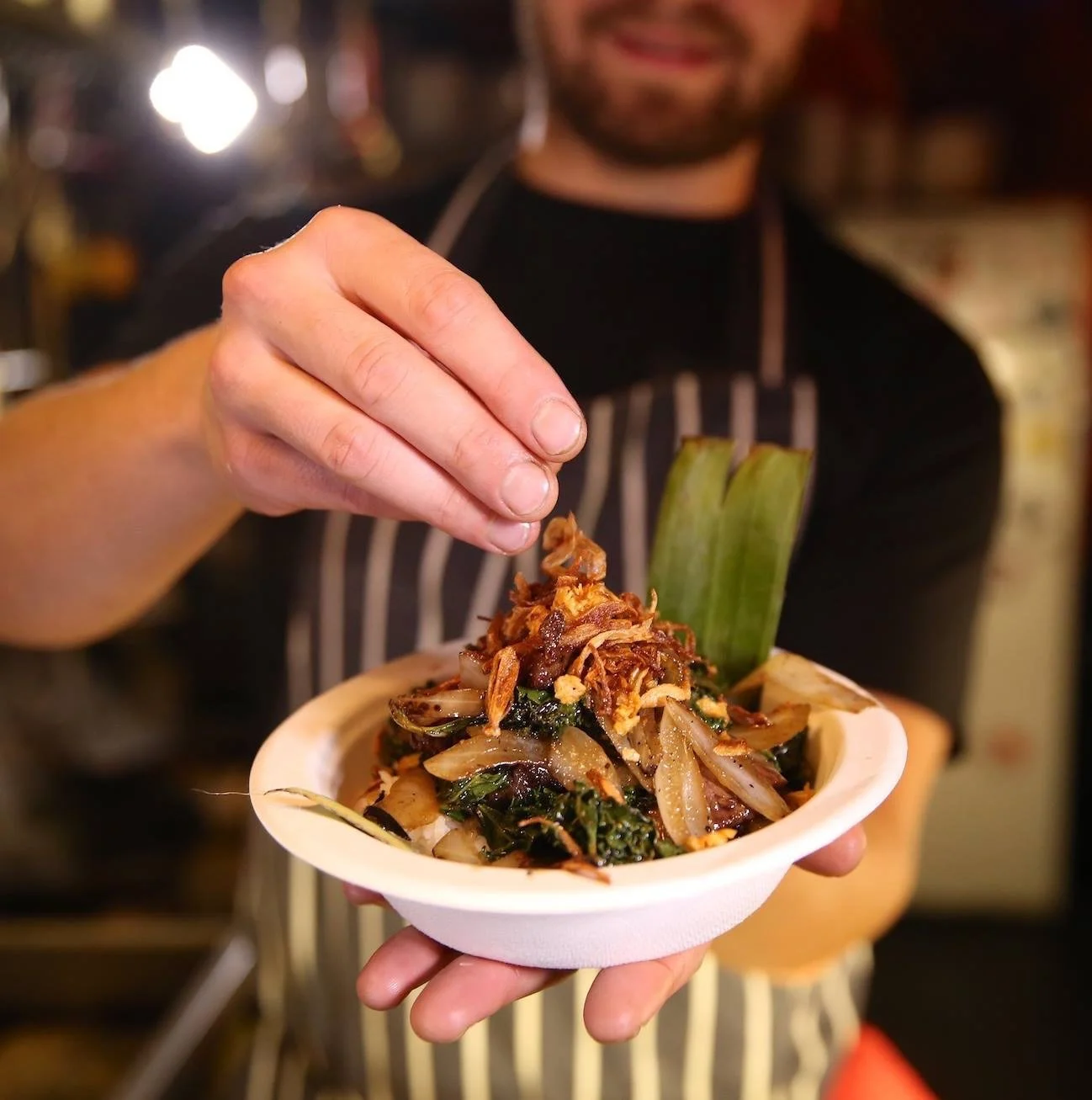Stir-fried beef flat iron with smoky jaew chilli jam, shallots, kale and flat rice noodles in a silver wok, recipe by Sebby Holmes