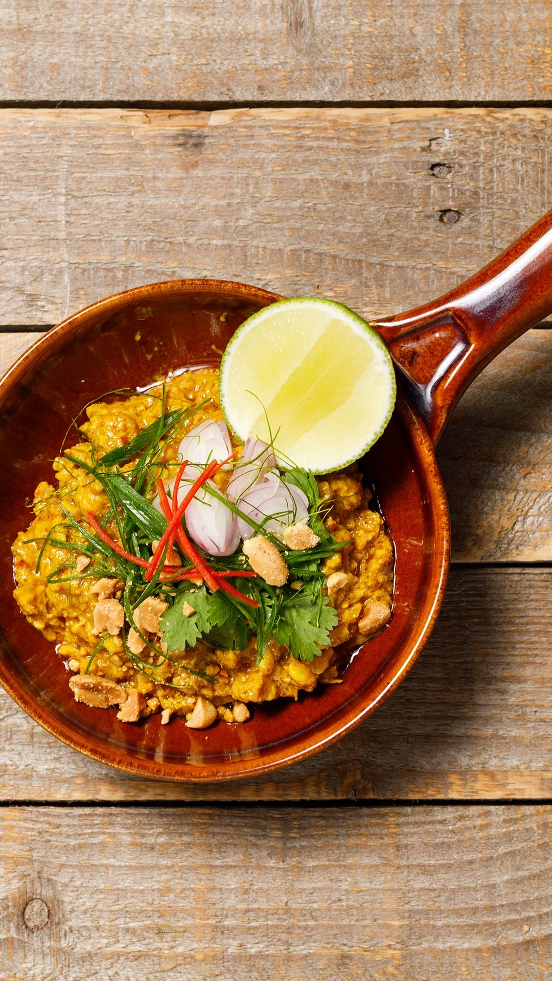 Minced chicken satay relish in a clay bowl with fresh coriander, sliced red chilli and toasted peanuts, recipe by Sebby Holmes