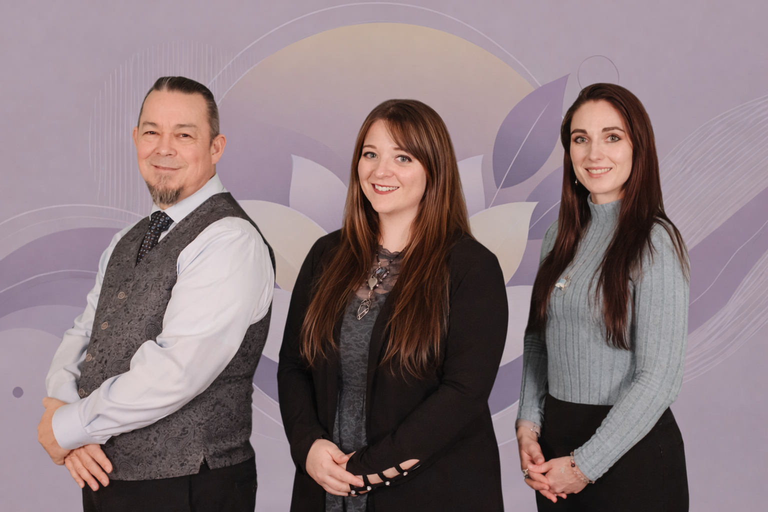 Three people standing side by side in front of a pastel graduation-themed mural, smiling at the camera.