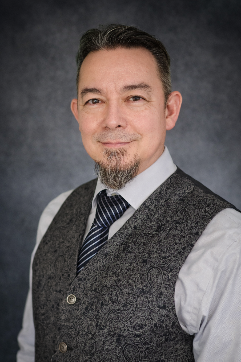 A woman and a man holding a certification, standing in front of a wall with a red neon sign that says 'HYPNOSIS'.