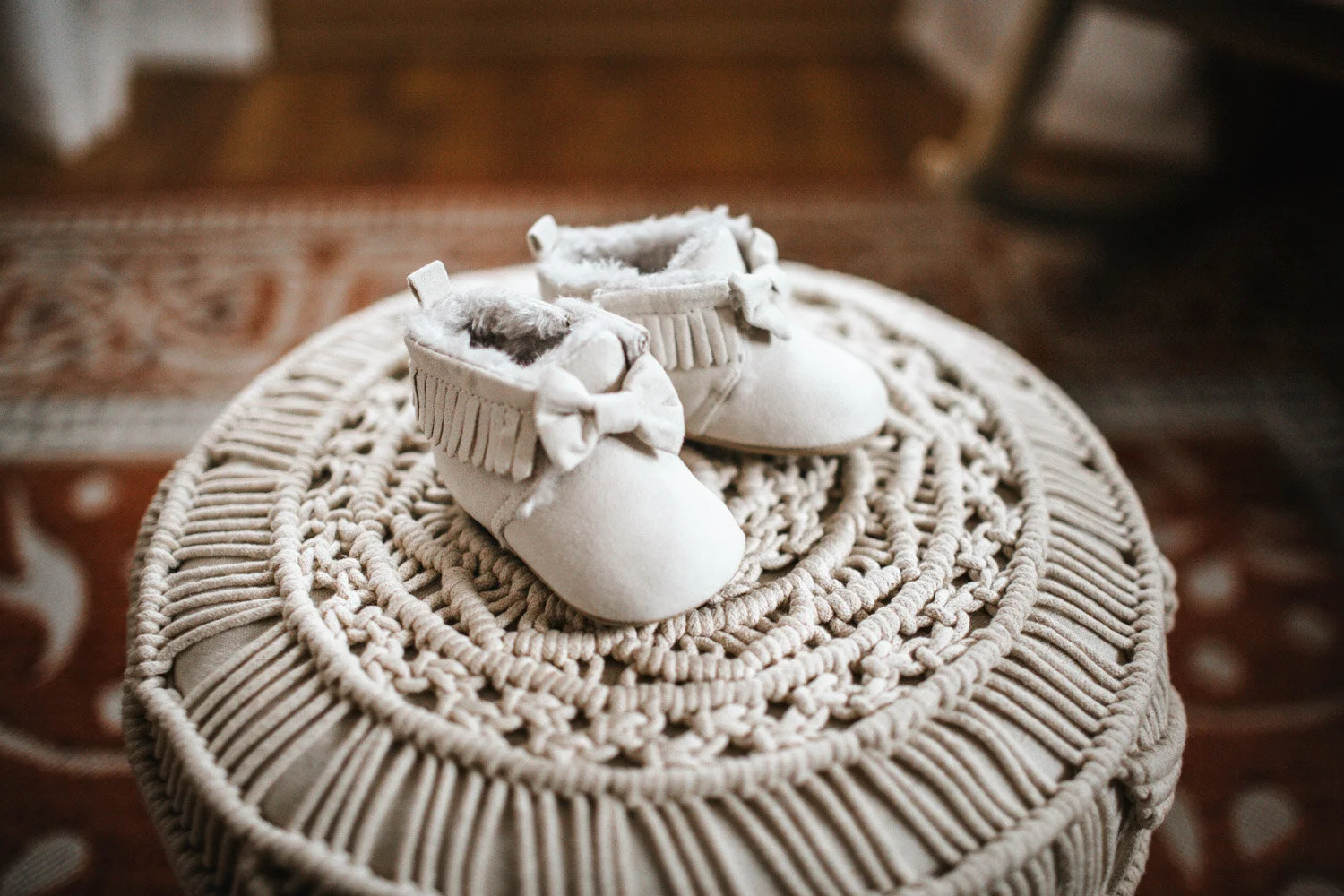 Newborn shoes placed on woven stool in nursery