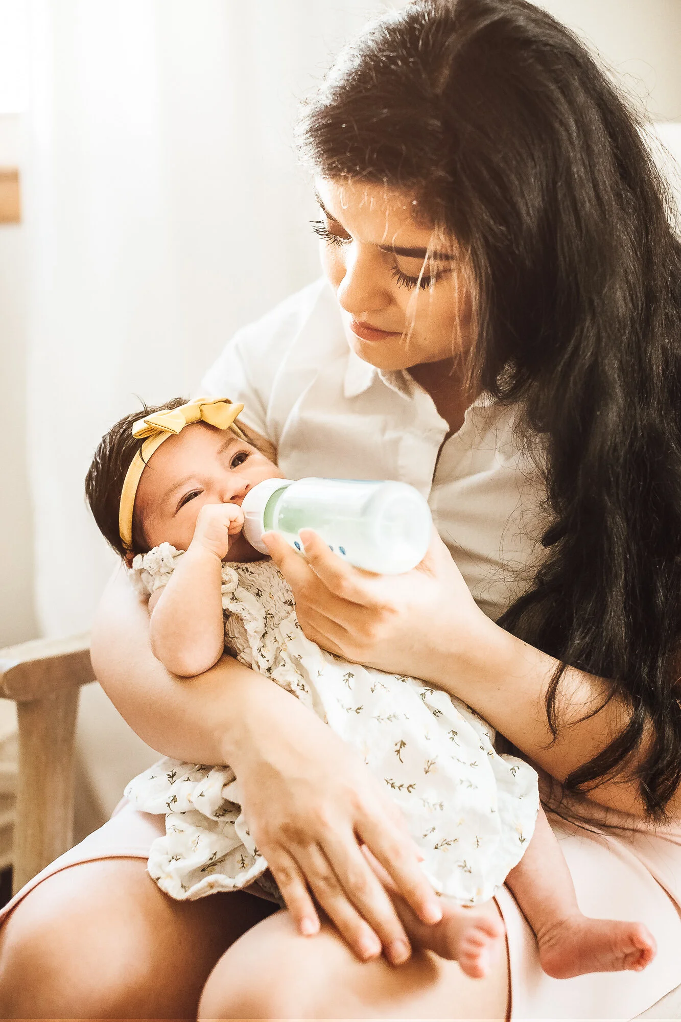 Mother feeding newborn girl with bottle