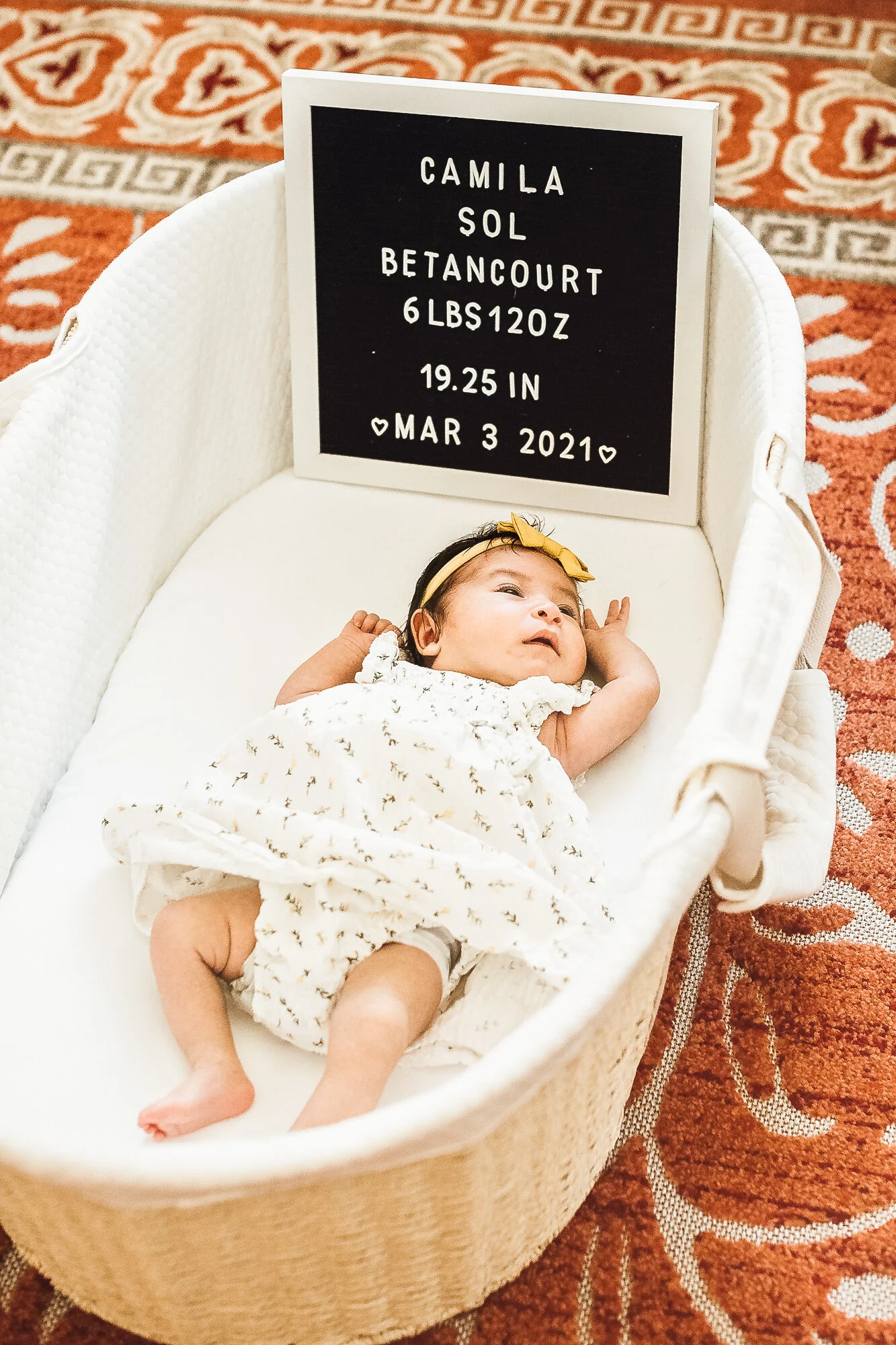 Newborn baby girl laying down awake