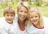 mother-with-son- and-daugher-at-each-side- smiling-outdorrs.jpg