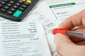 financial-documents-on-desk-with-person-hand-writing-on-them-and-a-calcualtor.jpg