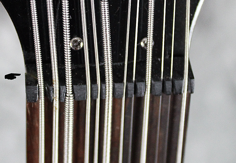 The nut is made of low-quality rosewood which breaks easily as this one has as shown on the left.