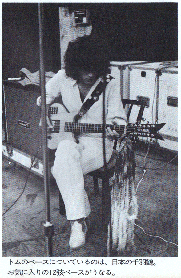 A senbazuru hangs from the neck of Tom Petersson’s Hamer Quad 12-string bass.