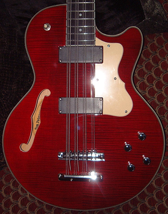 A cherry red TP-2 with the serial number sticker peeking out through the sound hole.