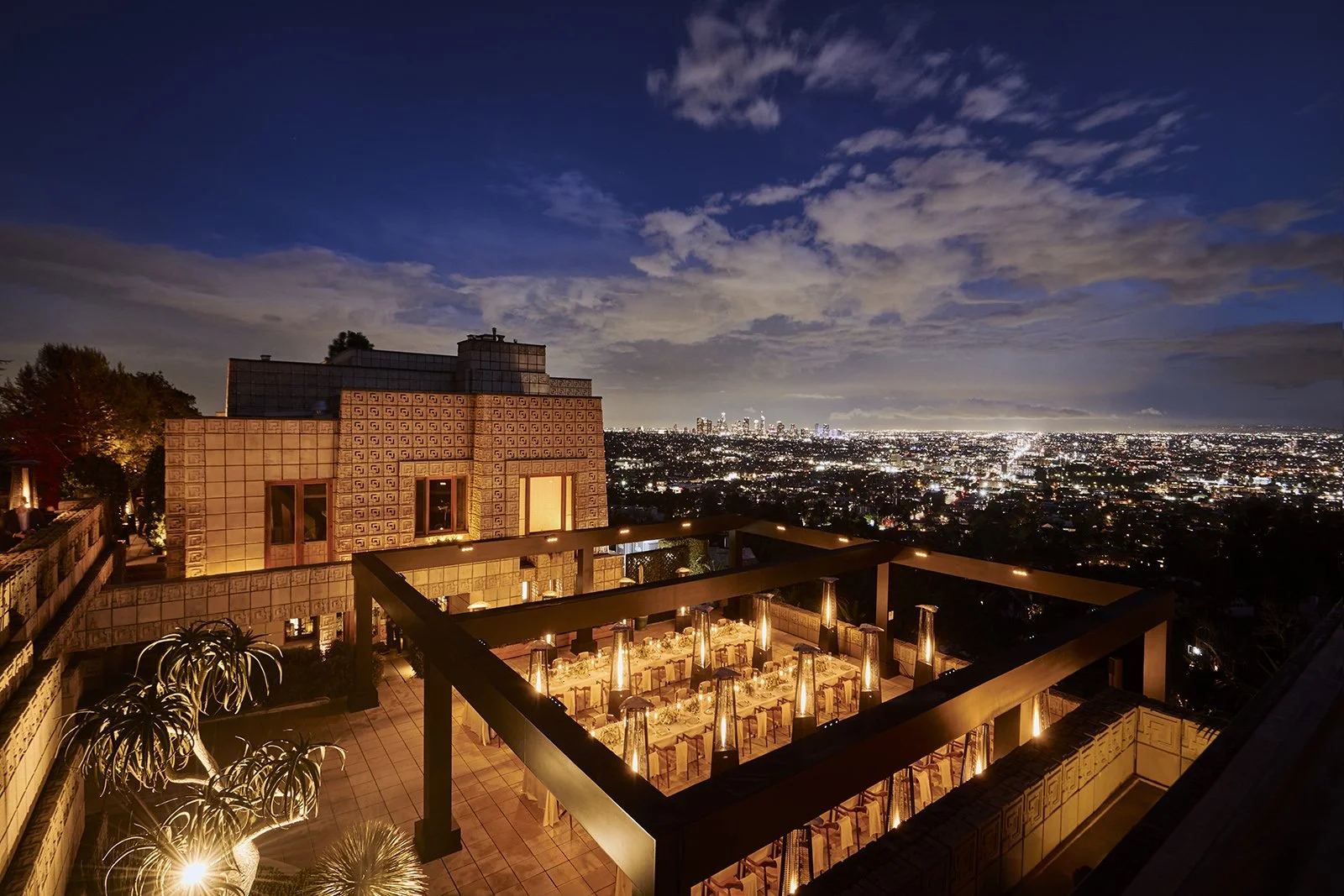 Nighttime cityscape view of a luxury outdoor event production hosted at the historic Frank Lloyd Wright Ennis House in Hollywood.