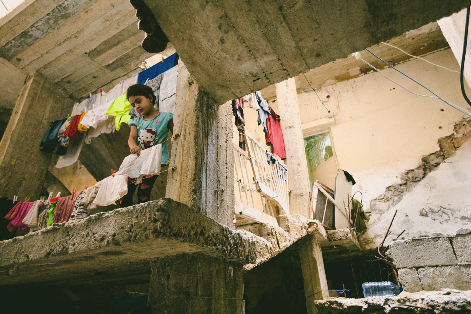  A little Palestinian girl collects laundry left out to dry. 