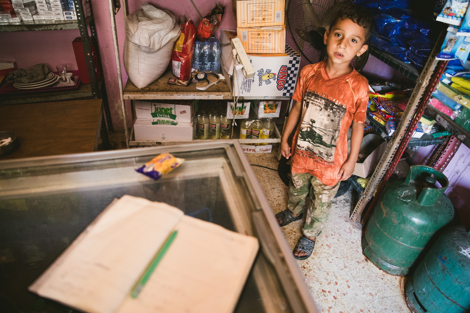  A young Palestinian boy inside a small shop. 