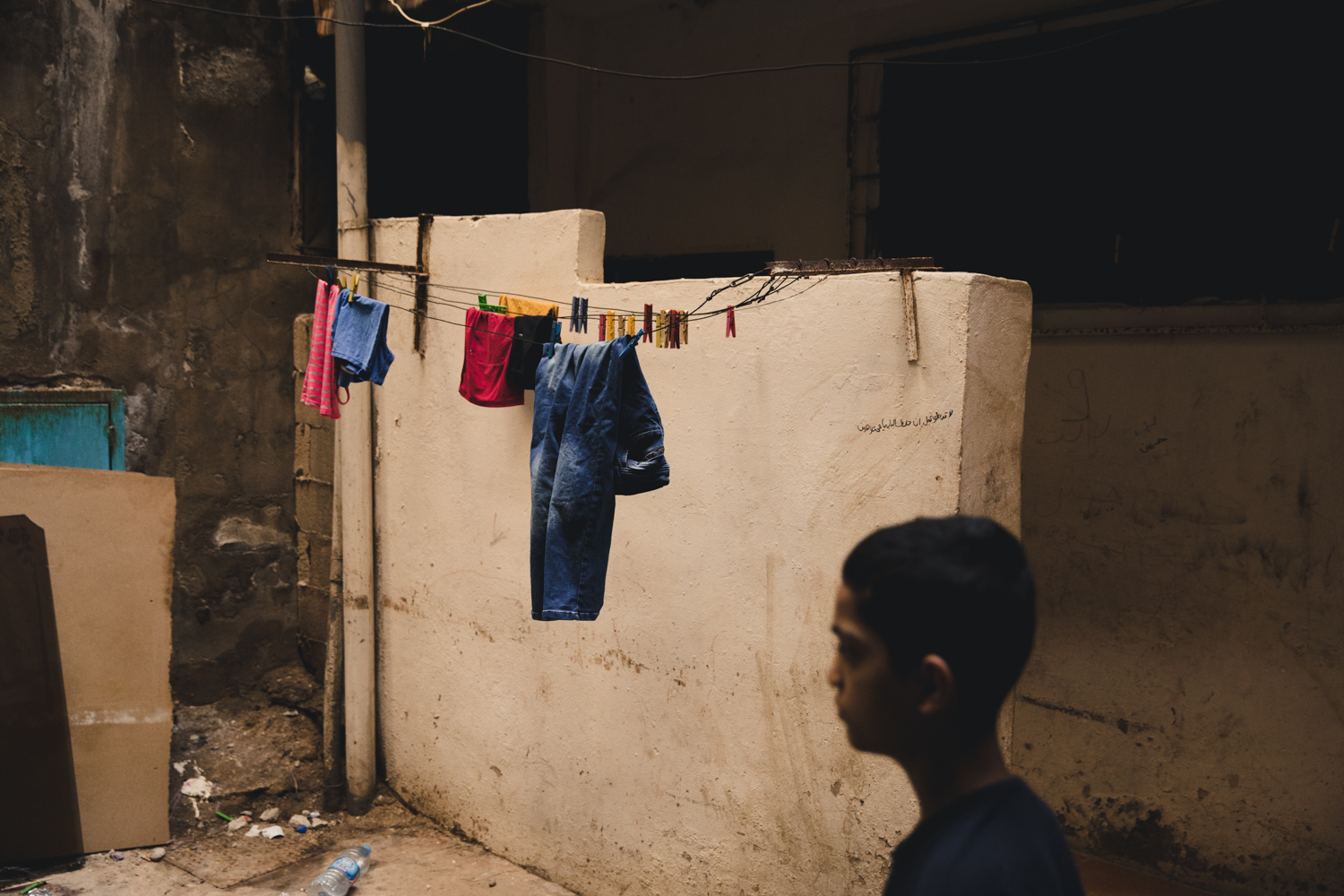  A young man walks past laundry drying inside an alleyway.  