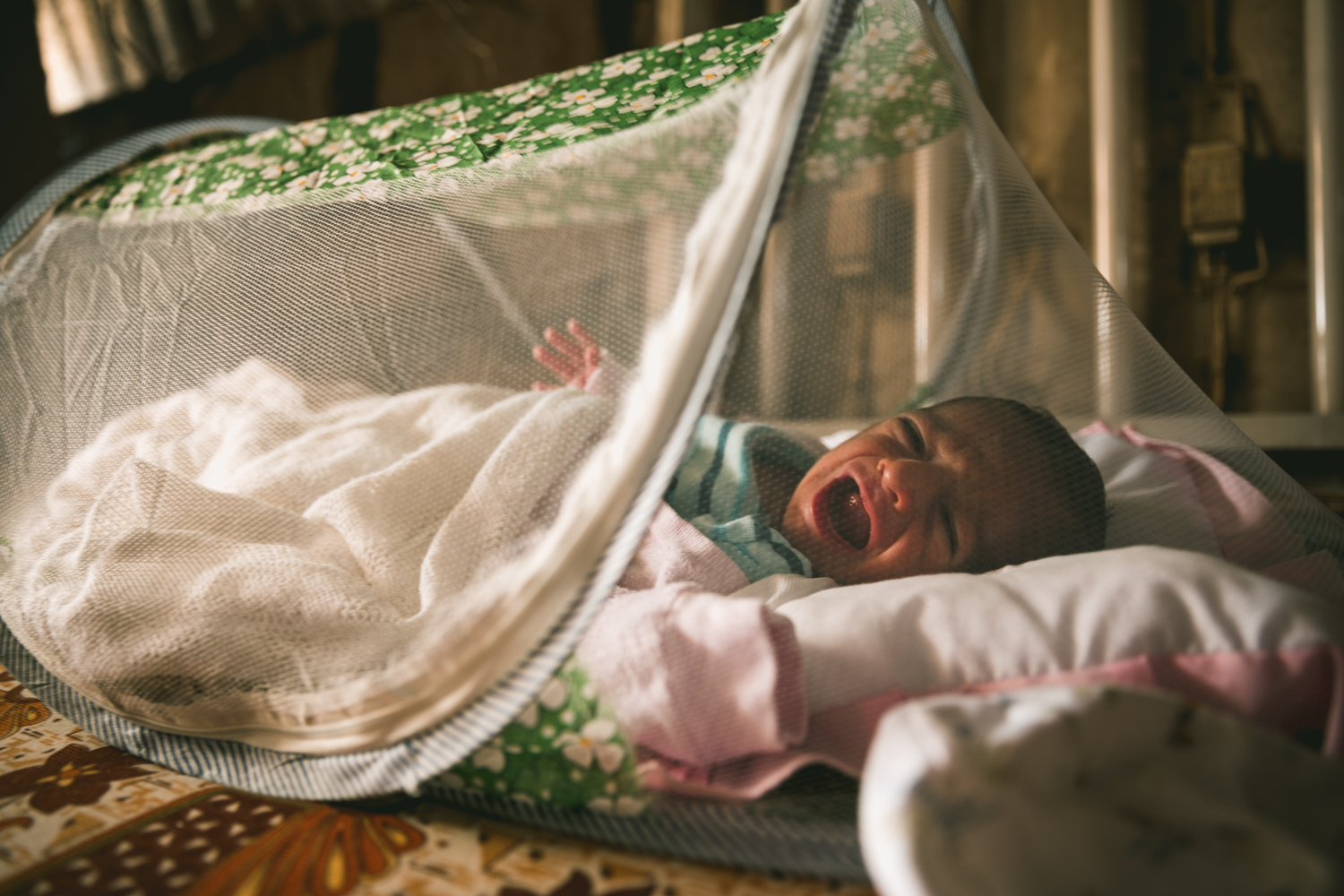  At the time of this photograph the infant was only five days old. A mosquito net protects her from insects. 